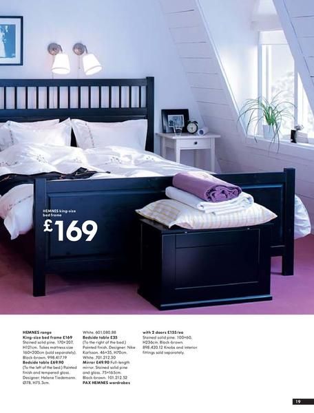 hemnes bedroom, black bed, light bedding and white side table .