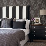 Black and white bedroom with striped headboard and a cool designed .