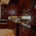Cherry wood cabinets and dark granite tops | Black granite kitchen .