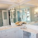 Luxurious bathroom with white beadboard vanity cabinets and drop .