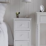 Maine white wooden bedside table with 3 drawers for storage .