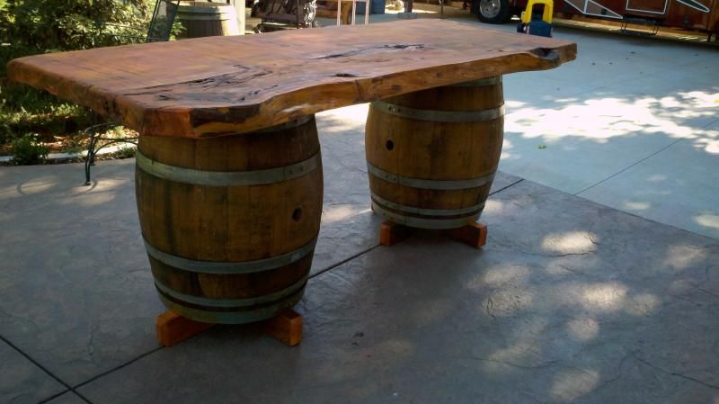 A rustic, vintage-looking dining table with #wine barrel legs .