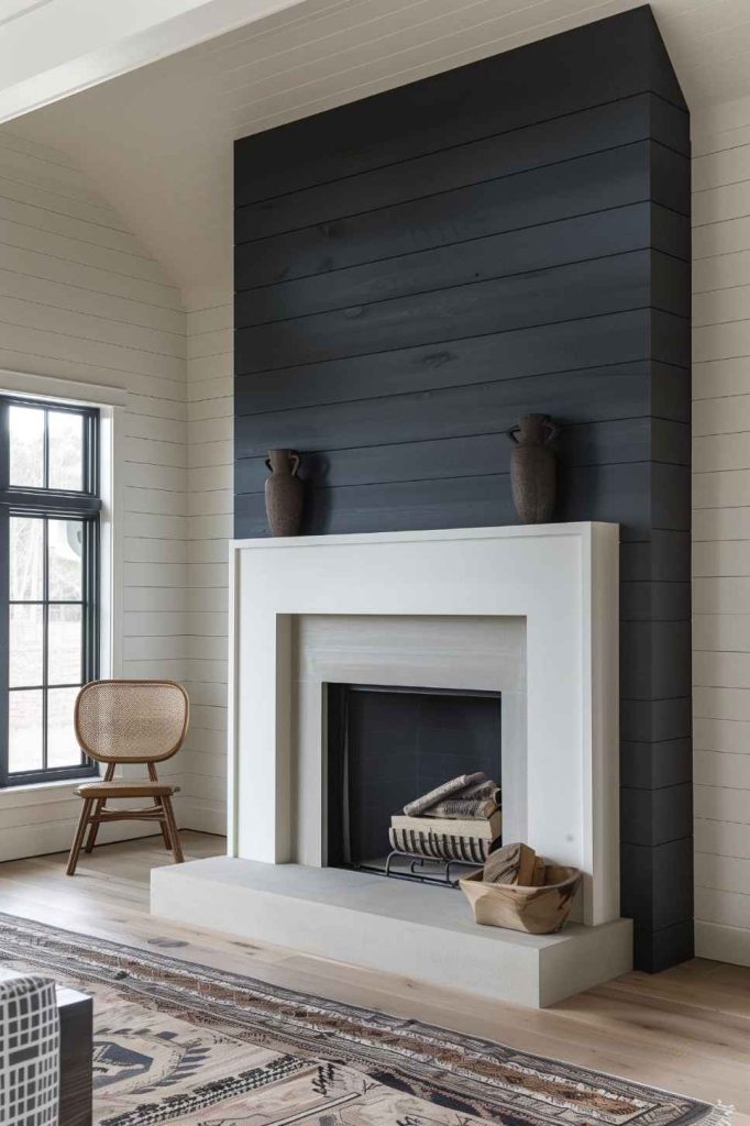 An expressive dark ribbed wall provides the perfect backdrop to the room with its commanding presence and contrasts artfully with the striking white farmhouse fireplace that serves as the undeniable focal point.