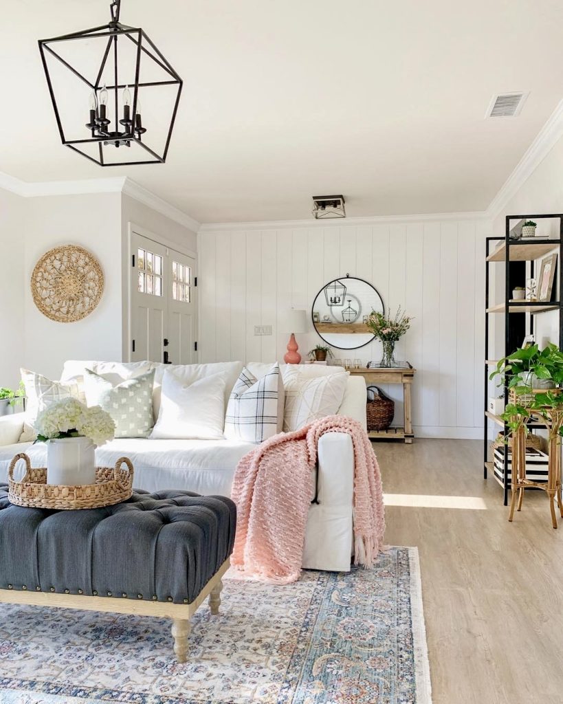 White slipcovered sofa with navy ottoman and blush throw