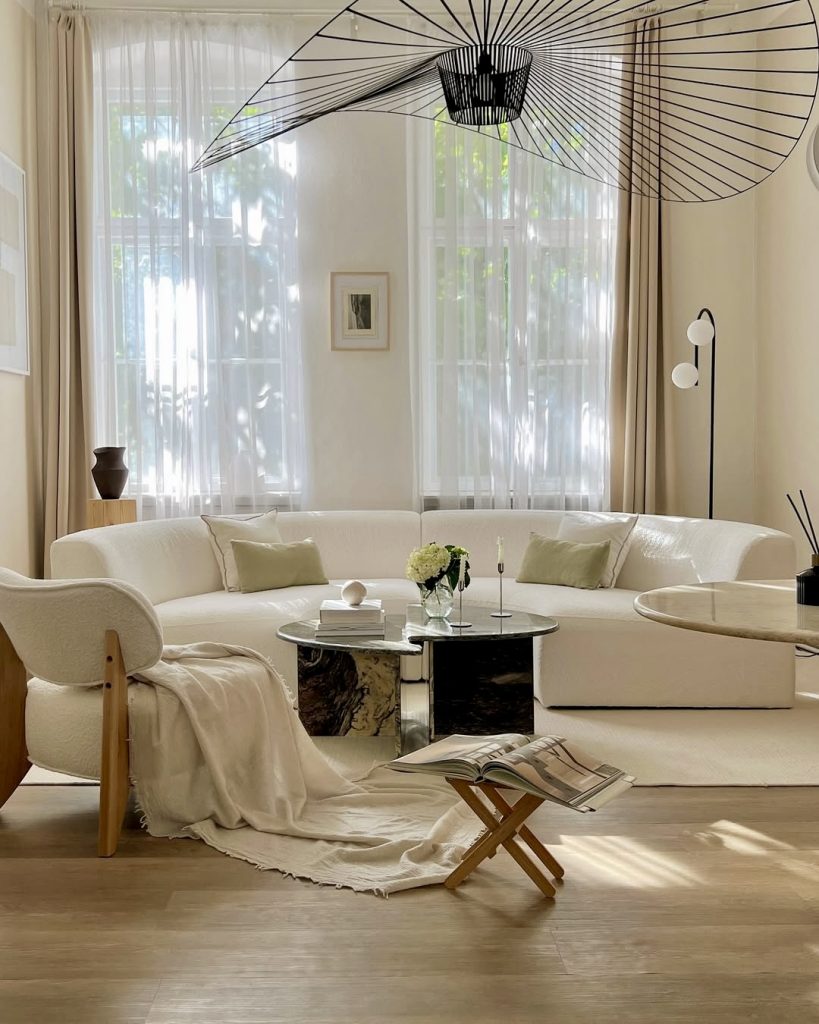 White Chesterfield sofa with sage pillows and ceramics