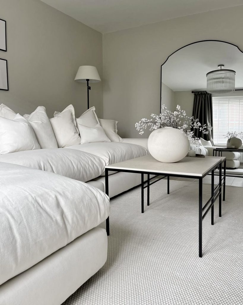 White sofa with colorful pillows and black-leg tables