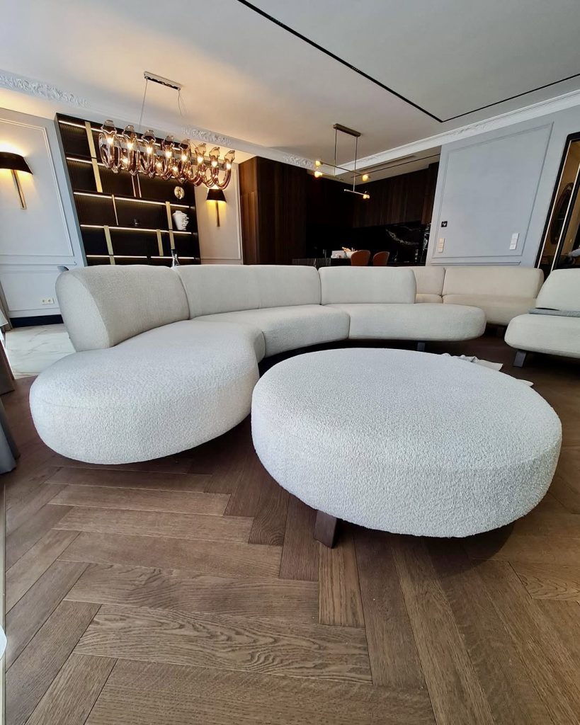 Curved white sofa with gold and bronze accents