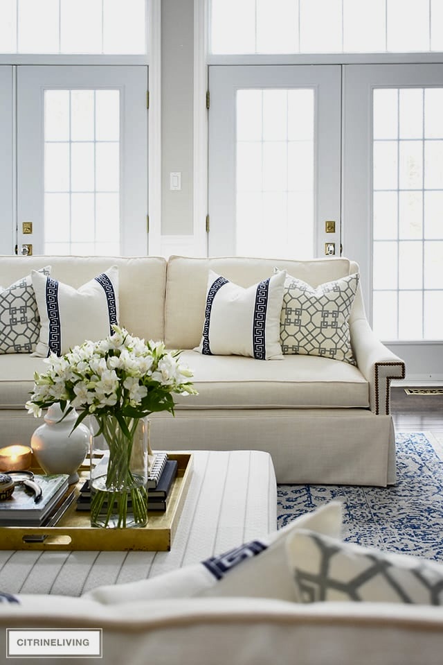 White sofa with navy blue patterned pillows in coastal living room