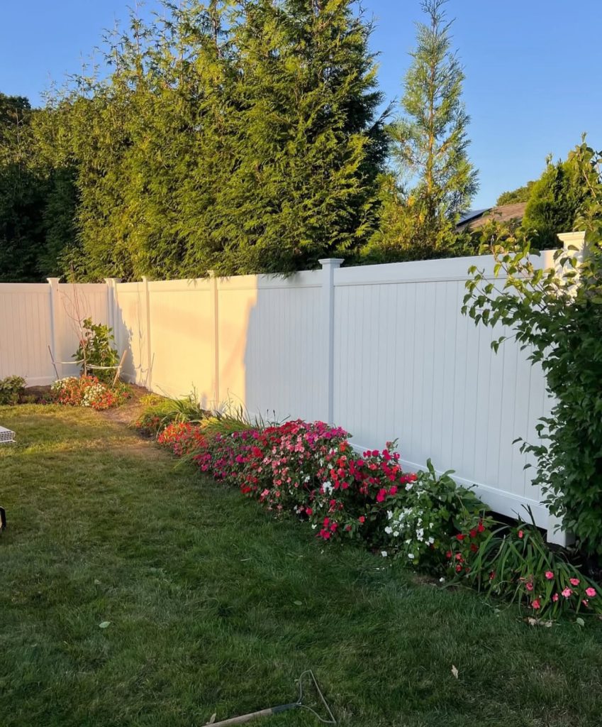 White vinyl picket fence with flowers