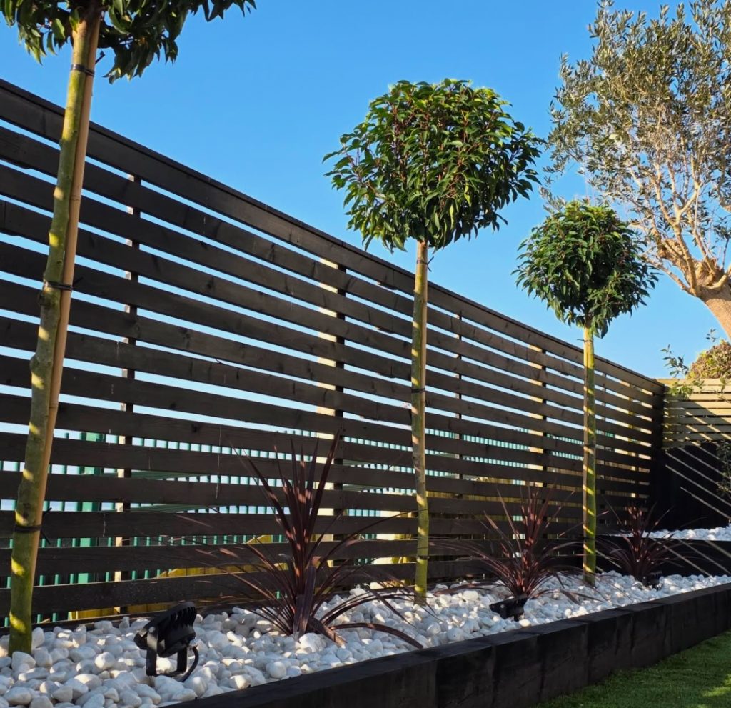 Charcoal slatted fence with rock garden