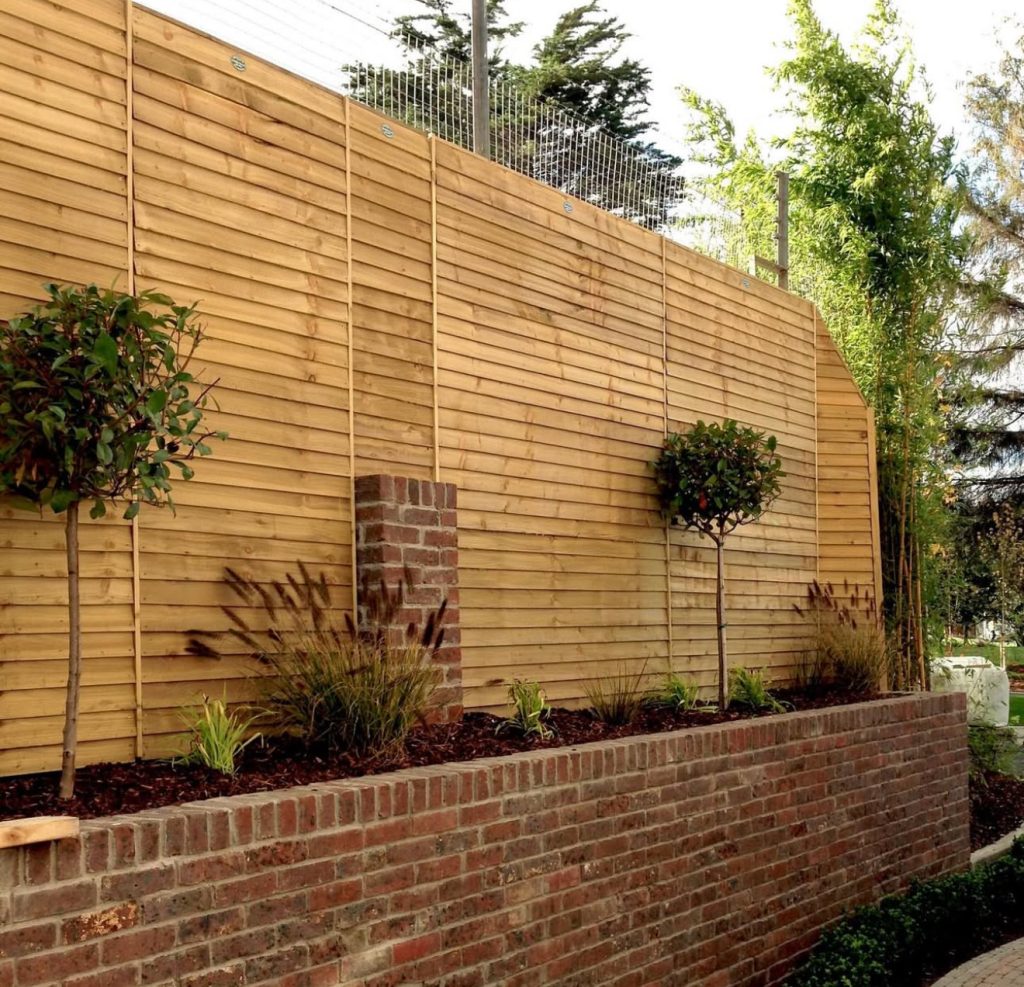 Tall timber fence with wire topper