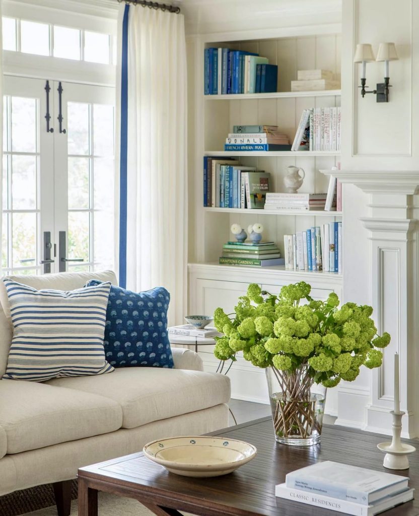 Coastal living room with blue and white pillows and floral accents