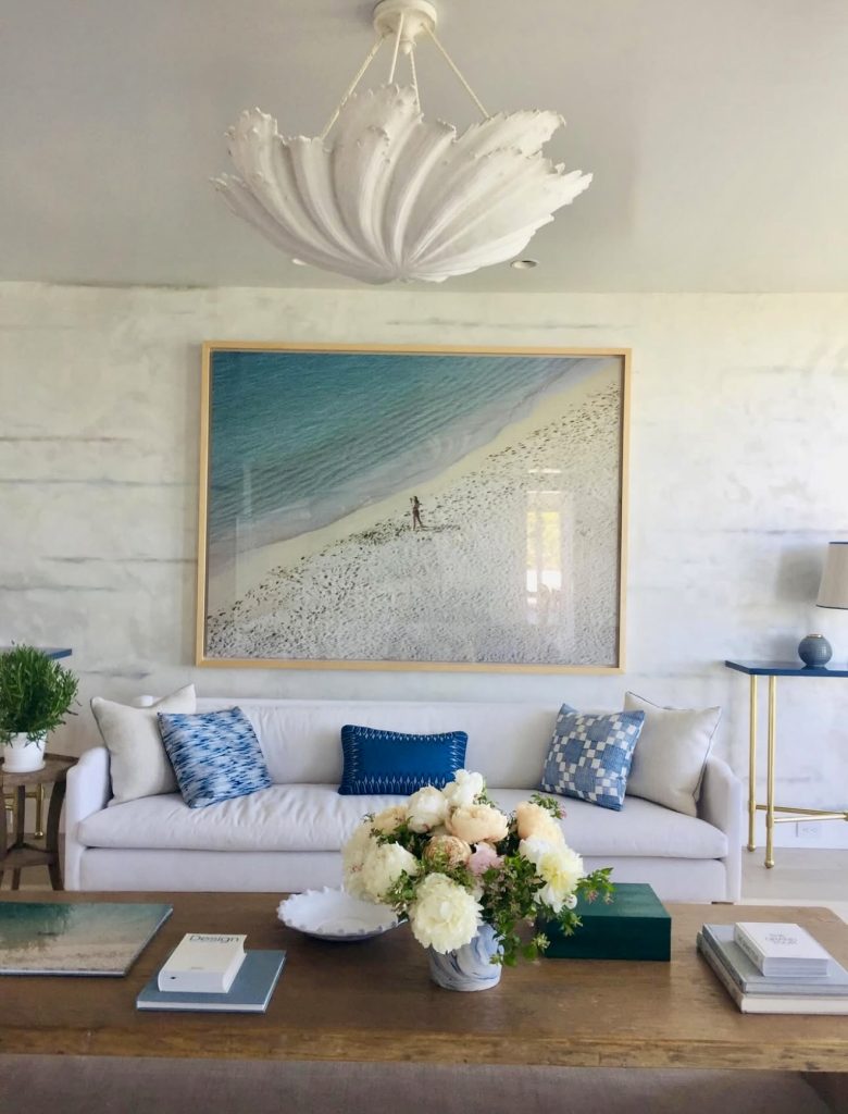 Beach-themed living room with blue pillows and white sculptural light