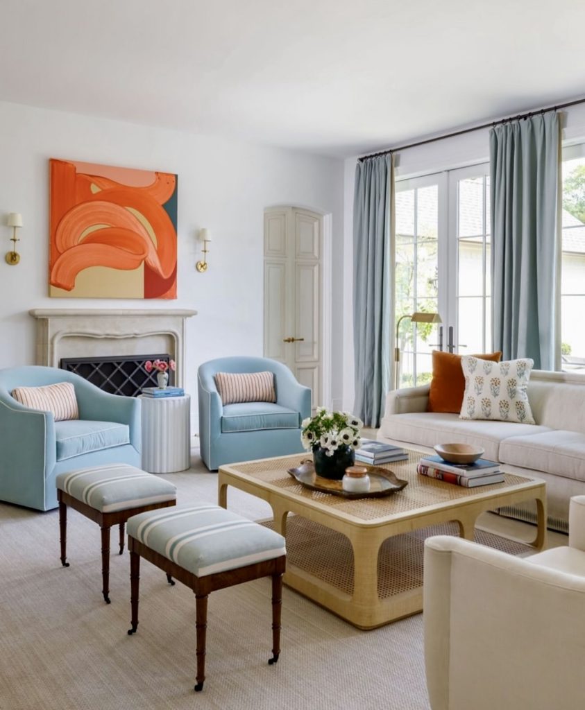 Coastal room with pink and orange accents and woven cane coffee table