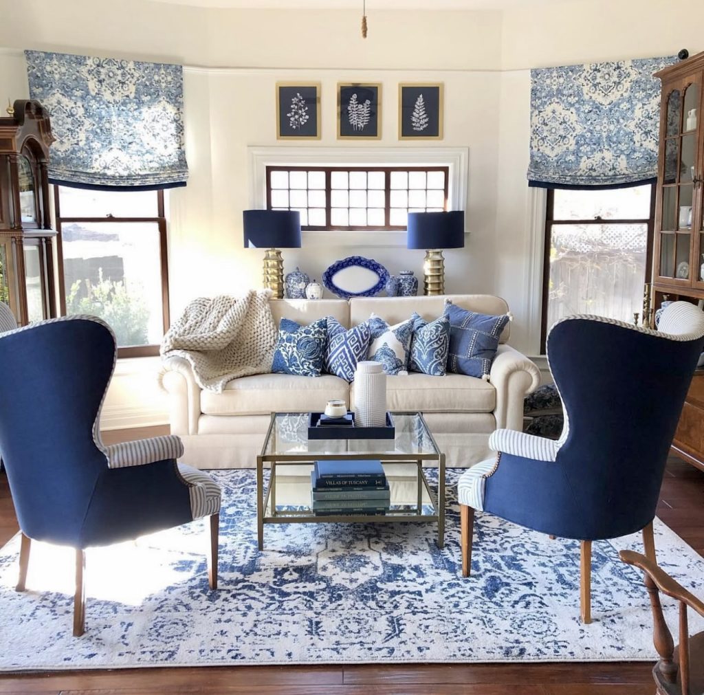 Blue velvet wingback chairs with cream sofa and brass accents