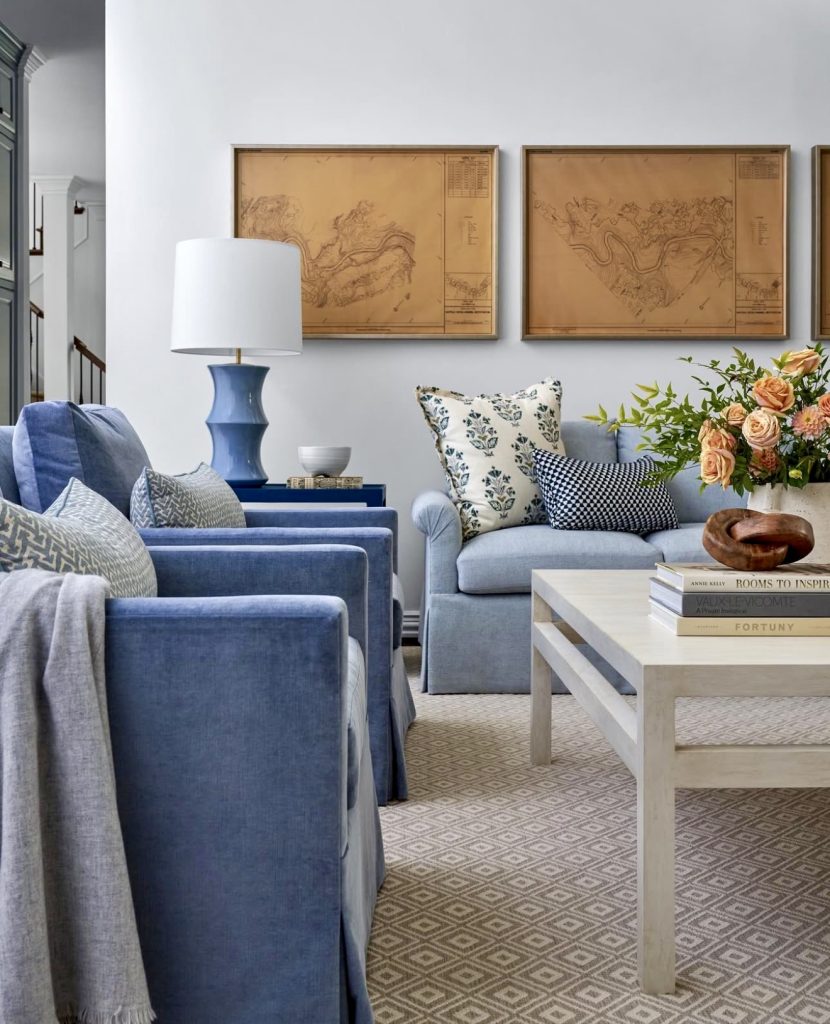 Blue upholstered sofa with vintage maps and floral pillows