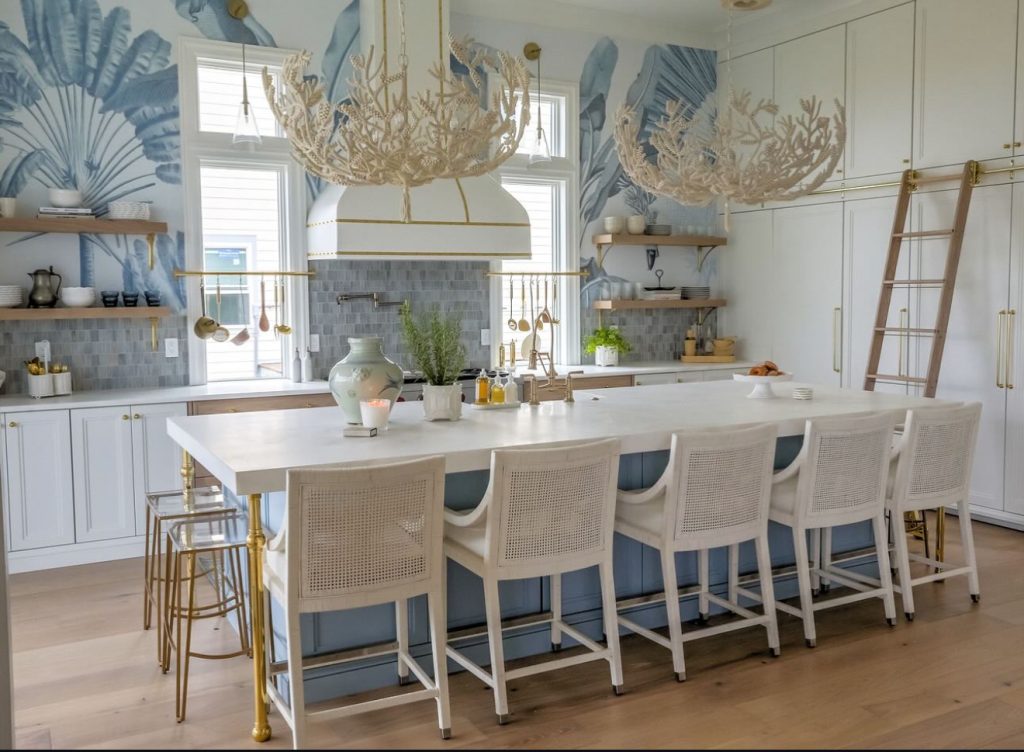 Coastal kitchen with coral-inspired chandeliers and blue island
