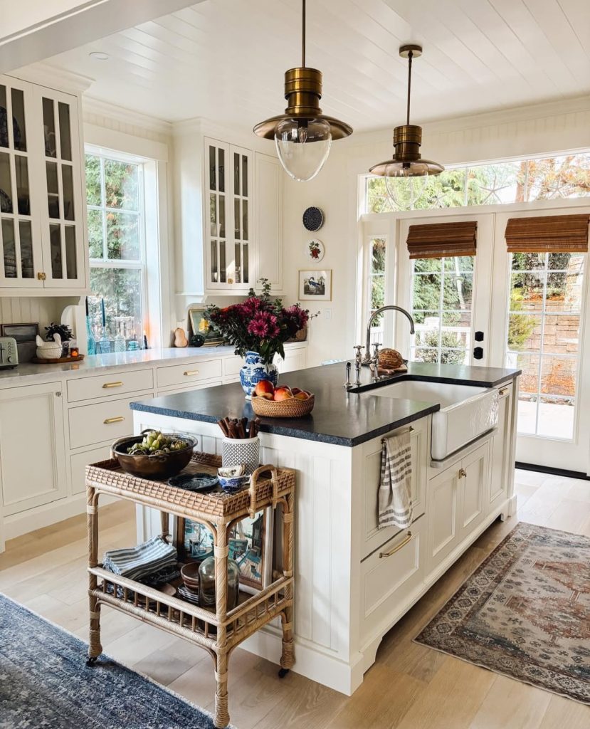 Traditional white cupboards with dark stone countertop and rattan accents