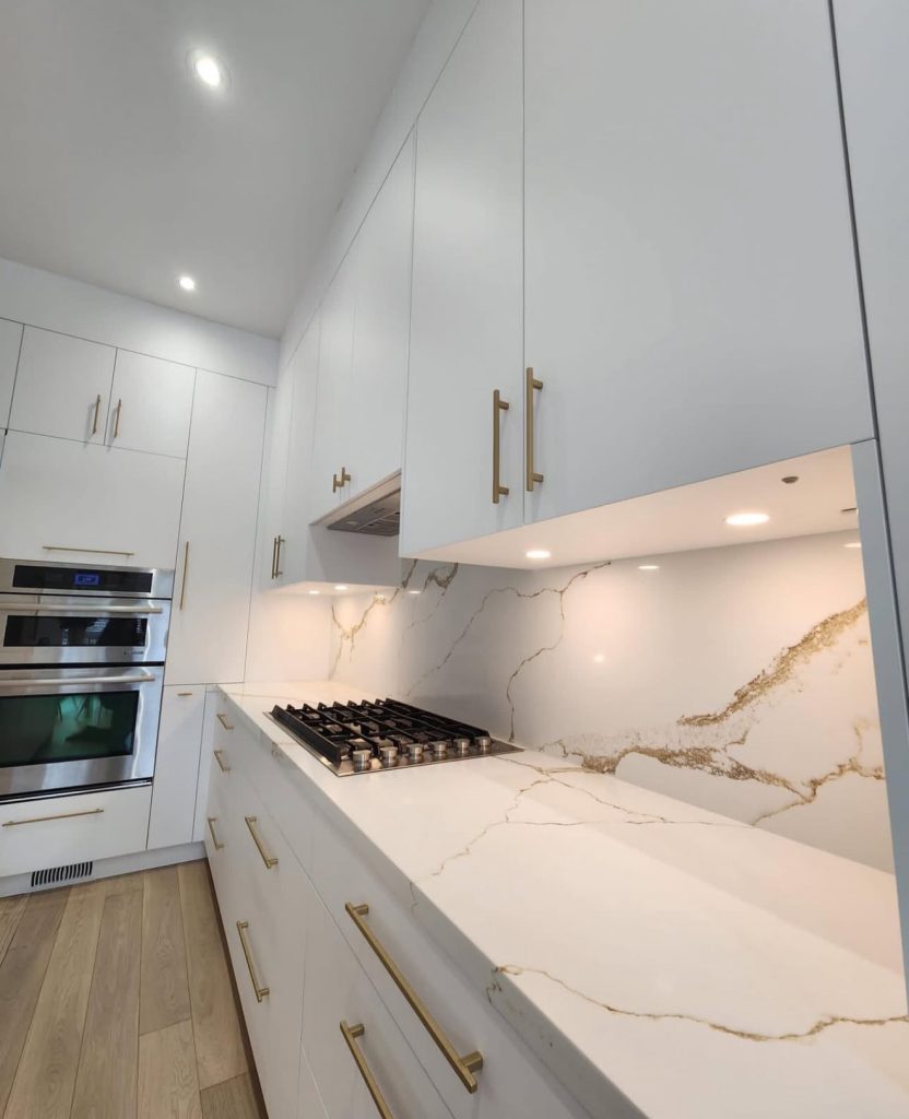 Minimalist kitchen with marble backsplash and brass pulls