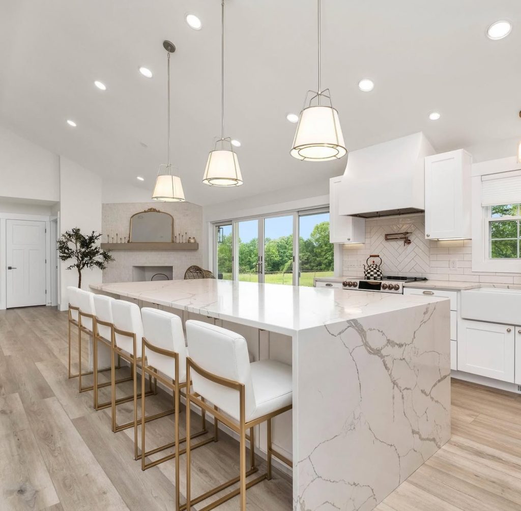 Kitchen with large marble island and white cabinetry