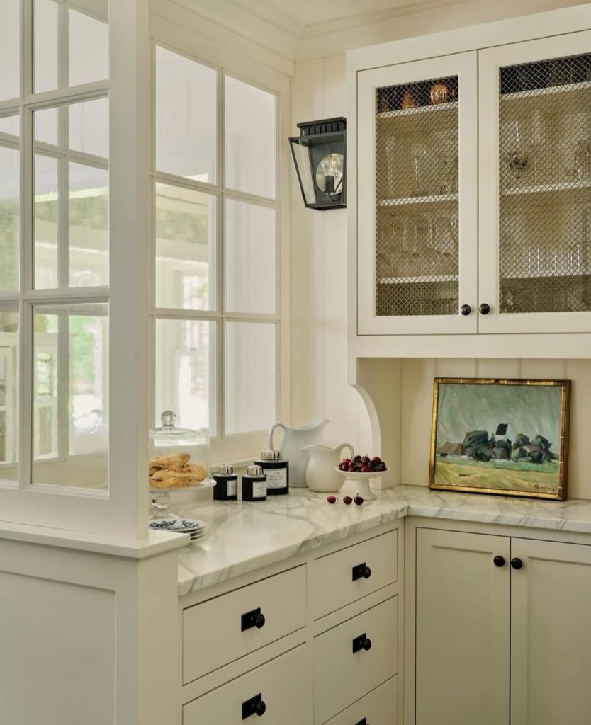 Vintage-inspired white cabinetry with mesh doors