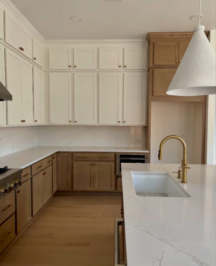 Kitchen with creamy upper cabinets and wood lower drawers