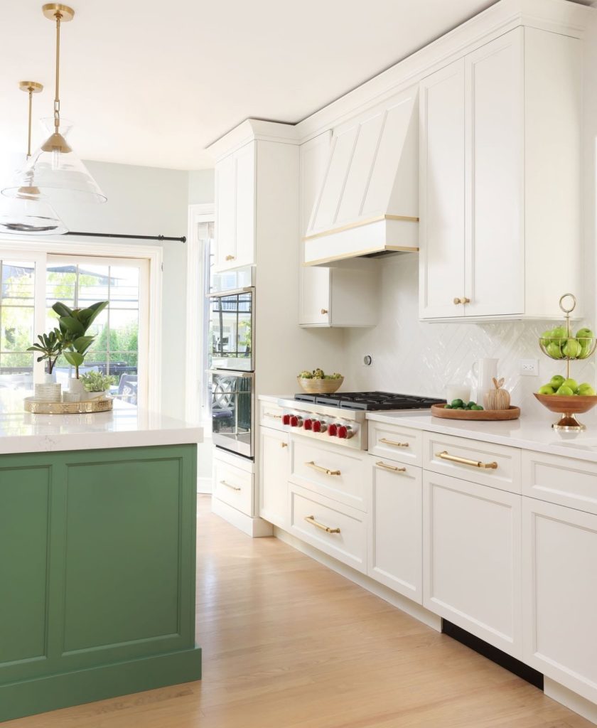 Kitchen with white cabinets and green island