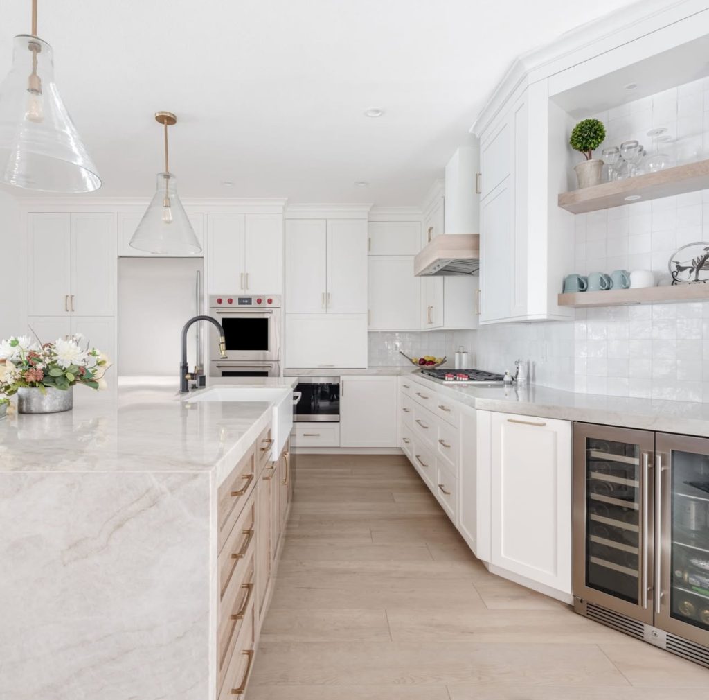 Kitchen with white cabinets, gold hardware, and pale wood island