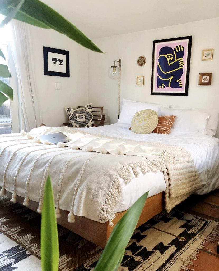 Boho-modern bedroom with framed artwork