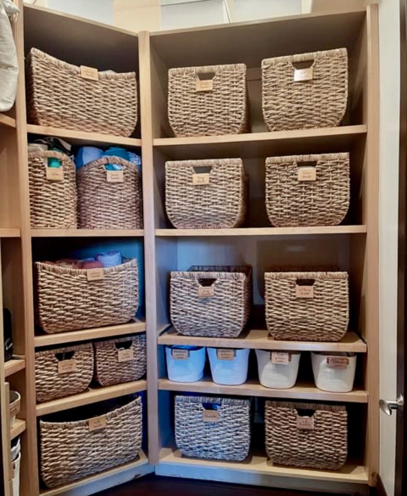 Corner linen closet with woven baskets