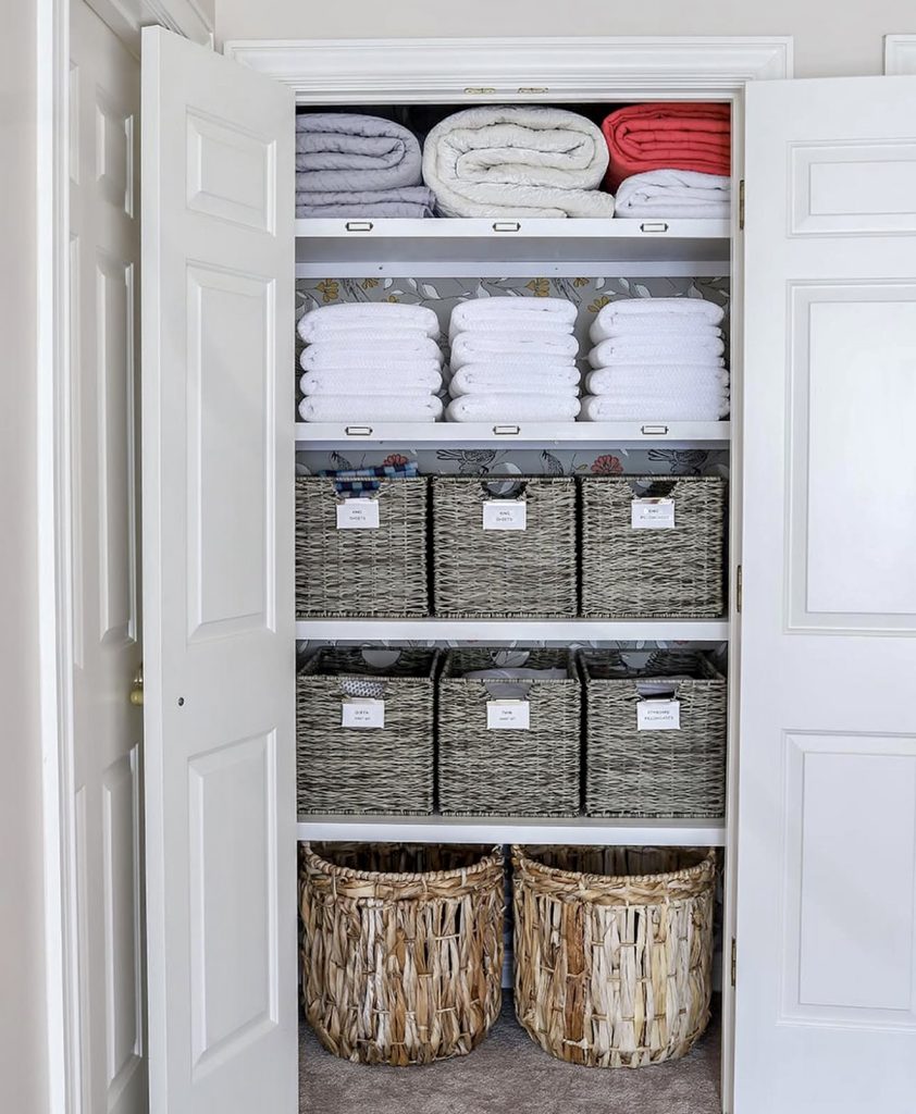 Linen closet with layered baskets and labels