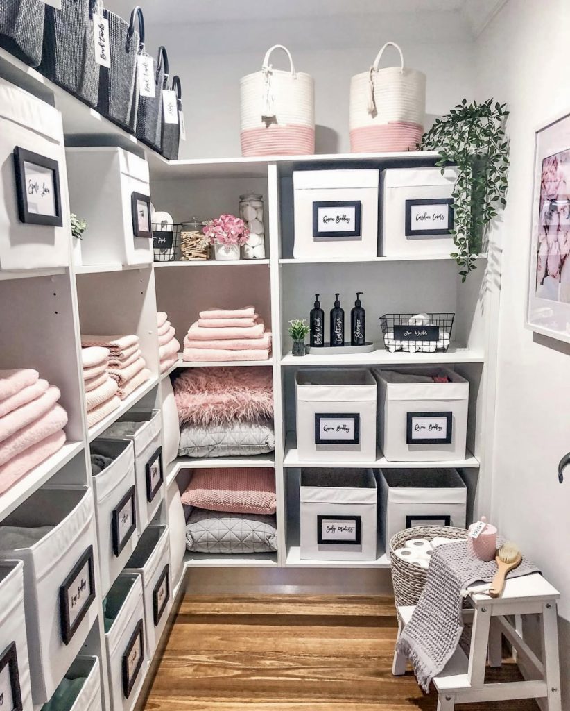 Pink and charcoal linen closet with labeled bins
