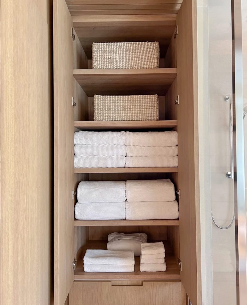 Natural wood linen closet with deep shelves