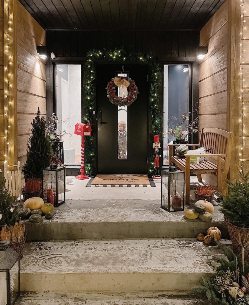 Modern porch with black door and holiday decor