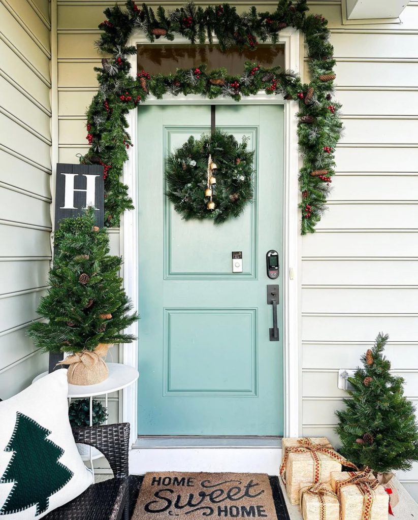 Green door with Christmas wreath and decorations