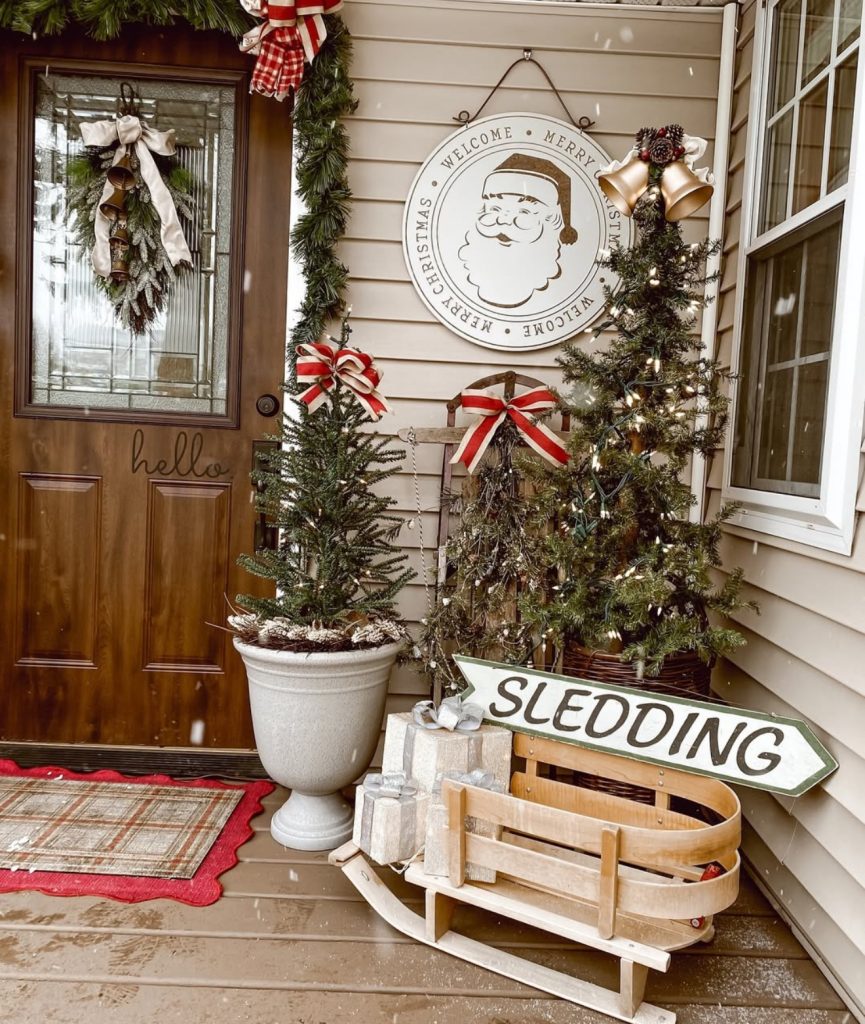 Christmas porch with sled and evergreen trees