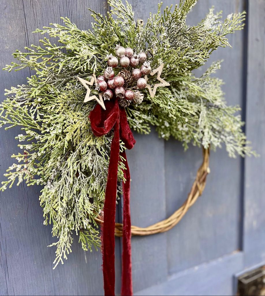 Frosted evergreen wreath with red velvet bow