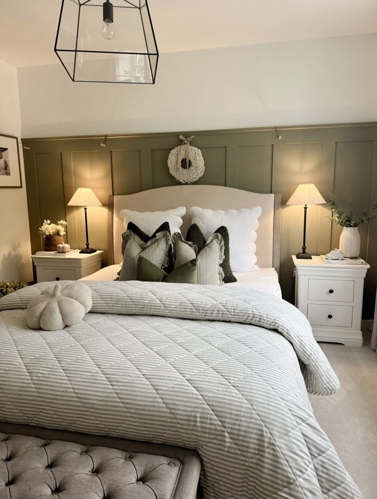 Bedroom with green accent wall and layered pillows