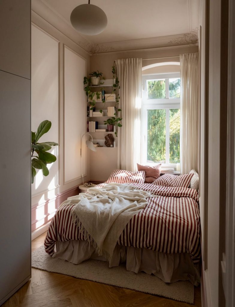 Bedroom with striped bedding and classical details