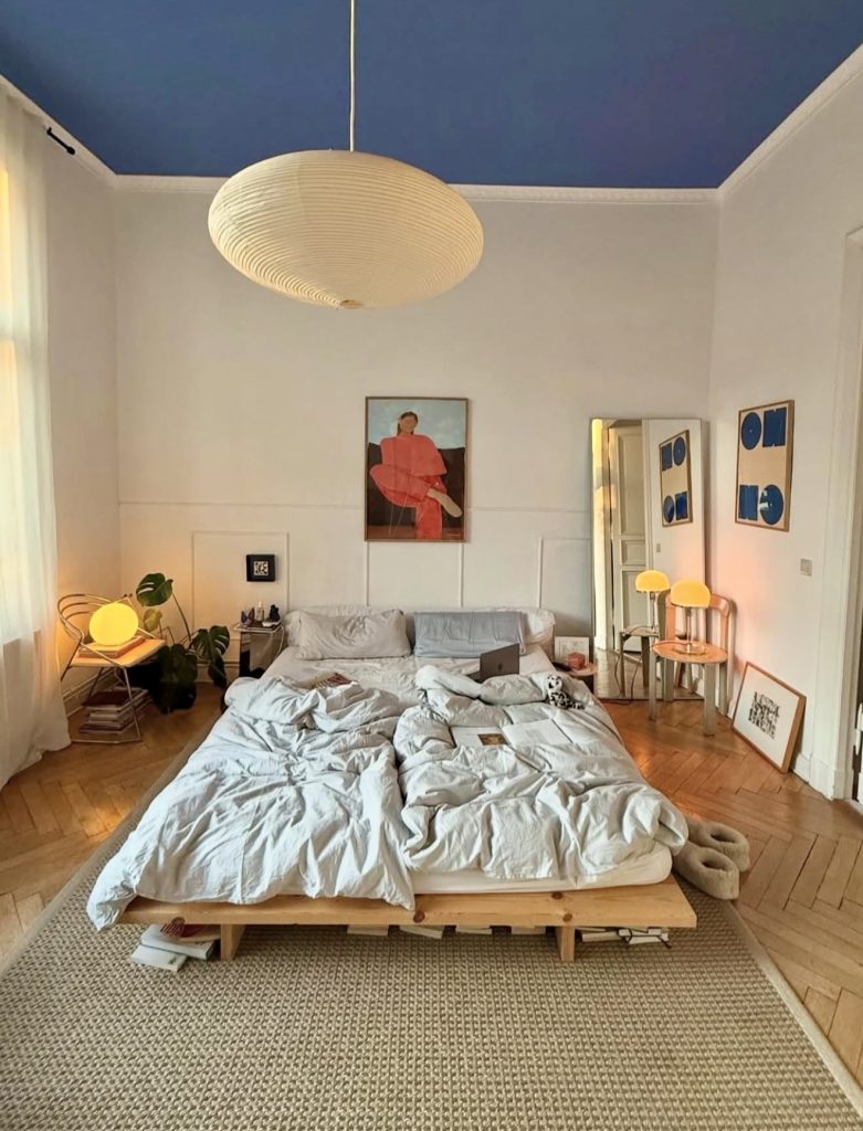 Bedroom with blue ceiling and minimalist decor