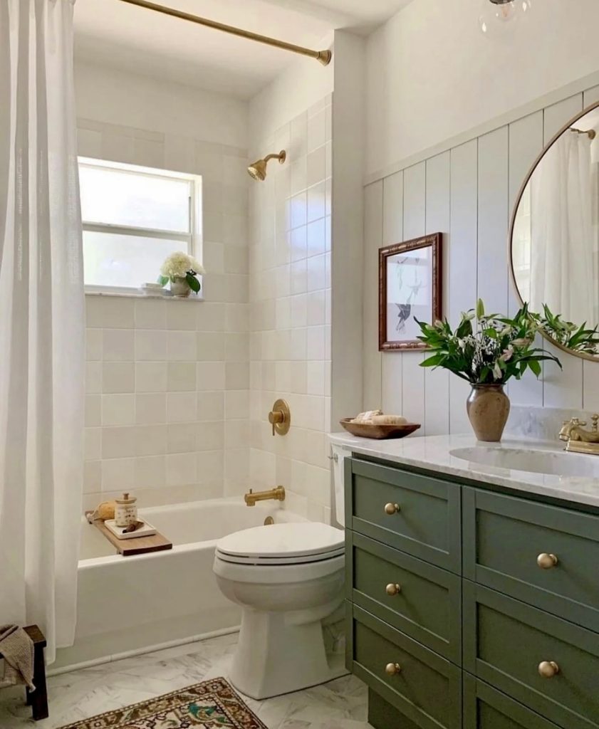 Bathroom with green cabinetry and gold hardware