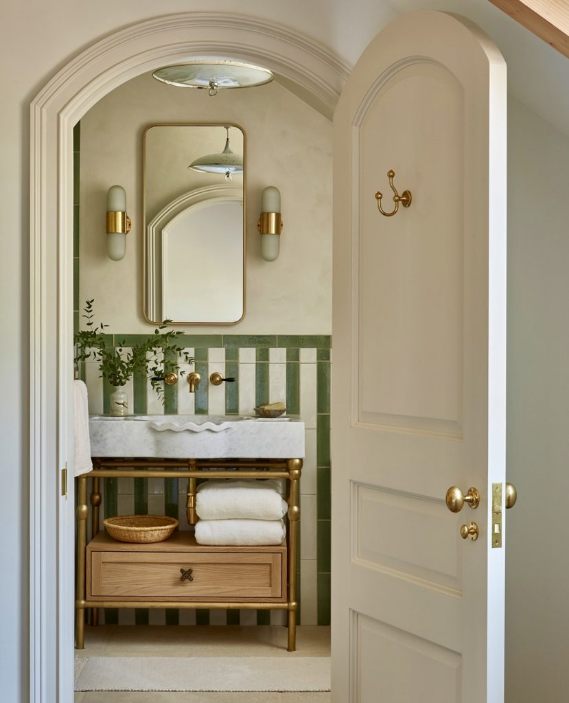 Bathroom with green striped tiles and gold accents