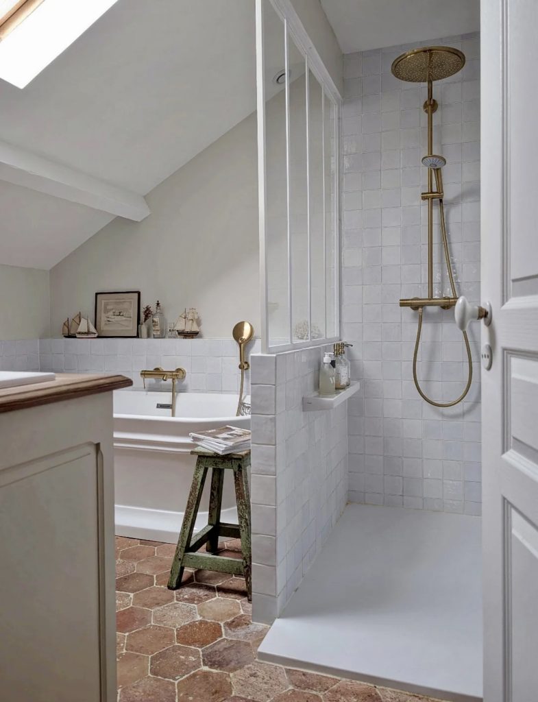Attic bathroom with terracotta flooring and freestanding tub