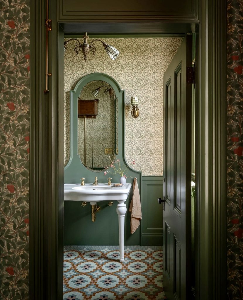 Powder room with green patterned floor and gold fixtures