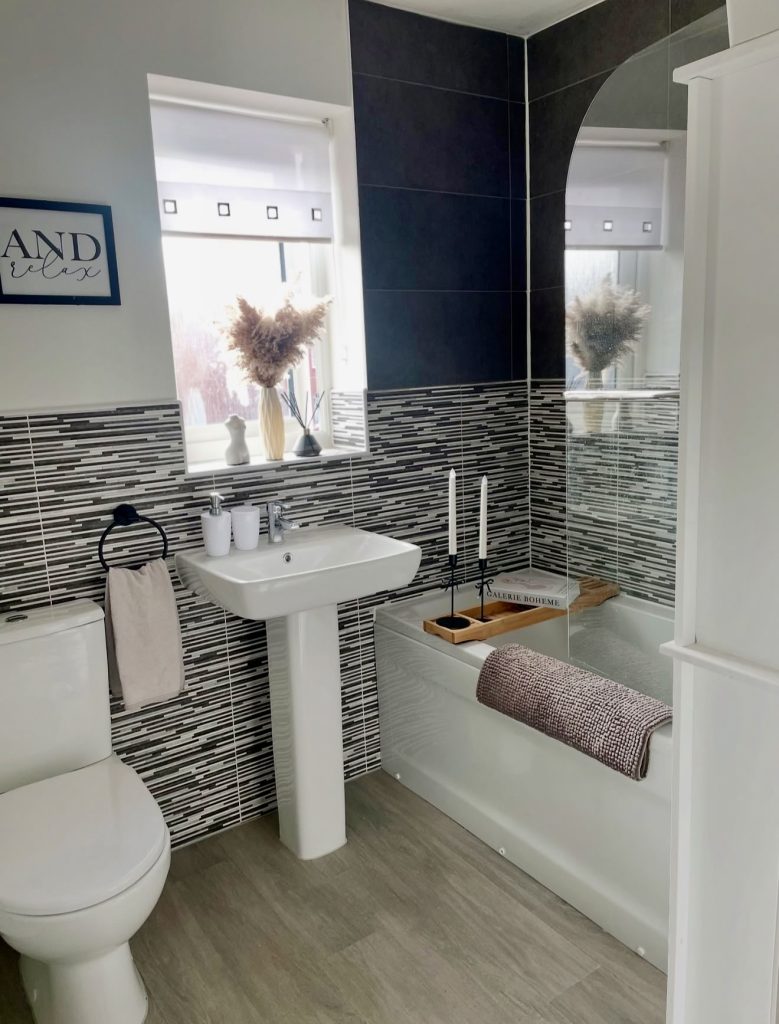 Bathtub with black and gray shades and wooden bath tray