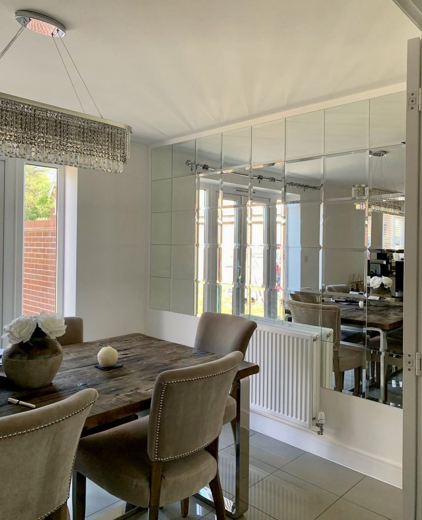 Polished Dining Room With Reflective Panel Wall