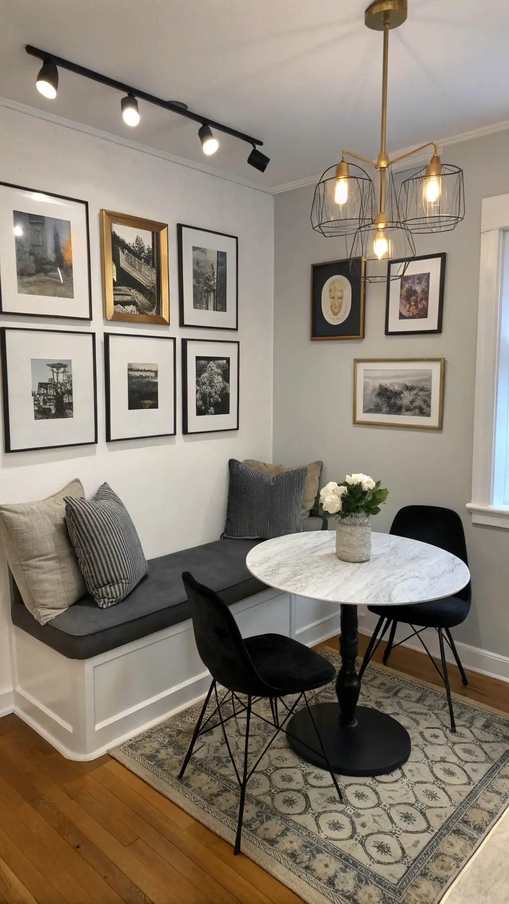 budget-friendly contemporary nook with black chairs, floating bench charcoal cushions, marble-effect table, gallery wall and white prints in brass frames, track lighting