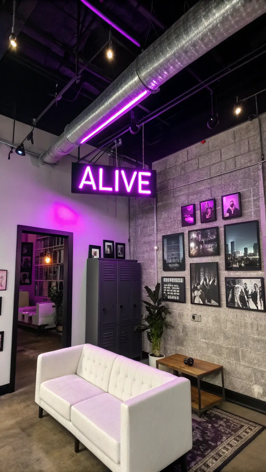 Low-angle view of industrial-chic corner living space with 12ft concrete ceilings, black ductwork, neon purple'ALIVE' sign, modular white seating, charcoal walls, vintage locker media cabinet, and black-and-white cityscape photos.