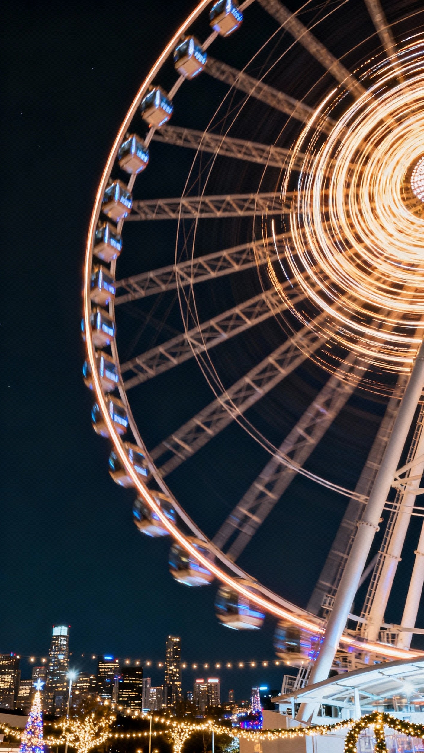 Urban City Photography - Nighttime Vibrance: Long Exposure Cityscapes - A Ferris wheel spinning with colorful light trails against the night sky.
