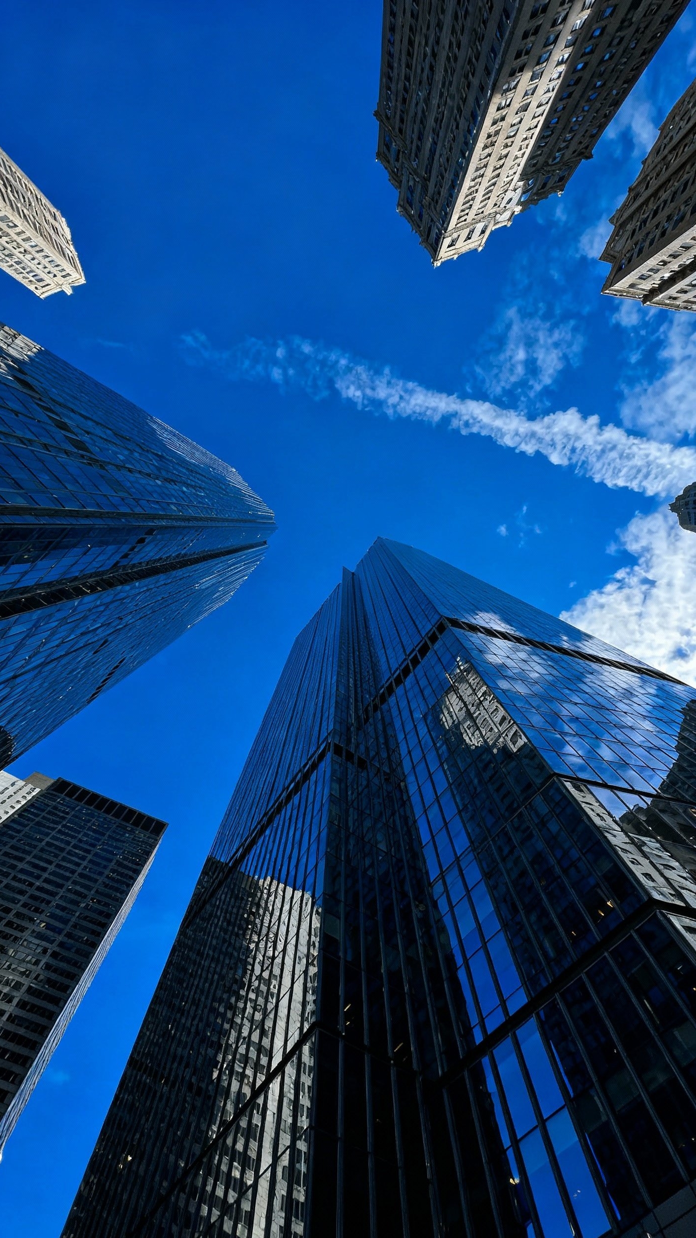 Urban City Photography - Architectural Majesty: Skyscrapers from New Angles - Dramatic low-angle shot of towering glass skyscrapers.